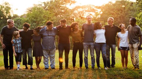 Eine Gruppe Menschen steht nebeneinander gereiht, Arm in Arm
