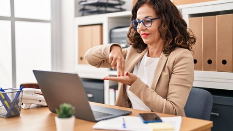 Frau führt Videogespräch mit Zeichensprache im Büro