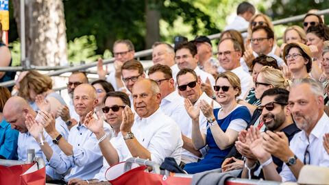 Auch zahlreiche Ehrengäste schauen sich den Festumzug von der Ehrentribüne der Vilco aus an.