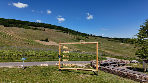Menschengroßer Holzrahmen, der im inneren des Rahmens stehen hat "Für das Hier und Morgen."