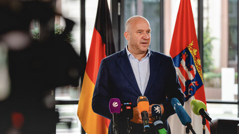 Umweltminister Ingmar Jung steht vor Mikrofonen in einer Interviewsituation.