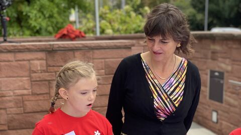 Grundschülerin Mayla erzählt der hessischen Staatssekretärin für Soziales und Integration Anne Janz wie sie die Kinderrechtefahne zusammen mit den anderen Schülerinnen und Schülern gestaltet hat