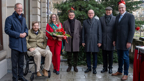 Ministerpräsident Rhein und Staatsminister Wintermeyer mit der Hessischen Weihnachtsbaumkönigin Alexa von Lewinski, dem Vizepräsident des Waldbesitzerverbandes, Roland Seel, dem geschäftsführenden Direktor des Waldbesitzerverbands, Christian Raupach, und Mitglied des Präsidiums und Vertreter für den Gemeinschaftswald, Frank Wiegand. Alle stehe nebeneinander vor dem Weihnachtsbaum.