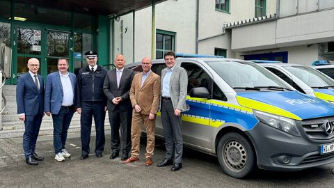 Landespolizeipräsident Robert Schäfer, MdL Frank Steinraths, Dienststellenleiter Michael Pagel, Innenminister Roman Poseck, Stadtrat Jörg Kratkey und Bürgermeister Andreas Viertelhausen stehen vor einem Polizeigebäude und neben einem Polizeiwagen zum Gruppenfoto aufgestellt.